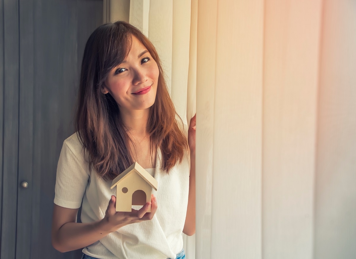 woman holding a house miniature