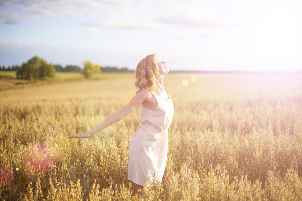 Young woman wearing a dress and posing in a field