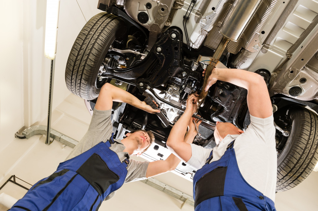 car mechanics working under a car