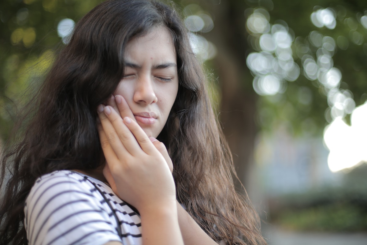 girl holding her chicks due to toothache