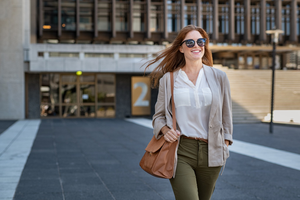 a woman carrying a bag walking on a street ready for challenge