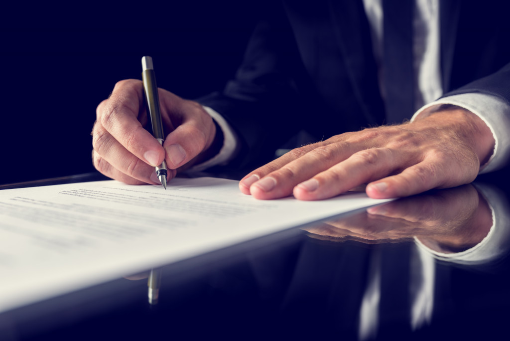 Retro image of lawyer signing important legal document on black desk