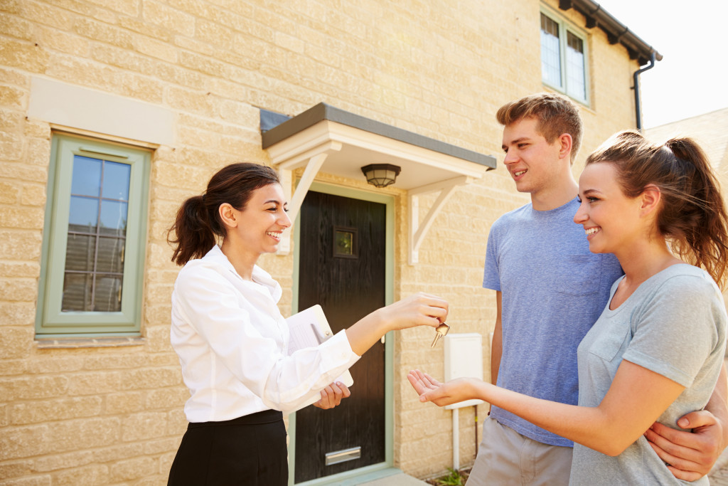 a couple getting keys from a real estate agent