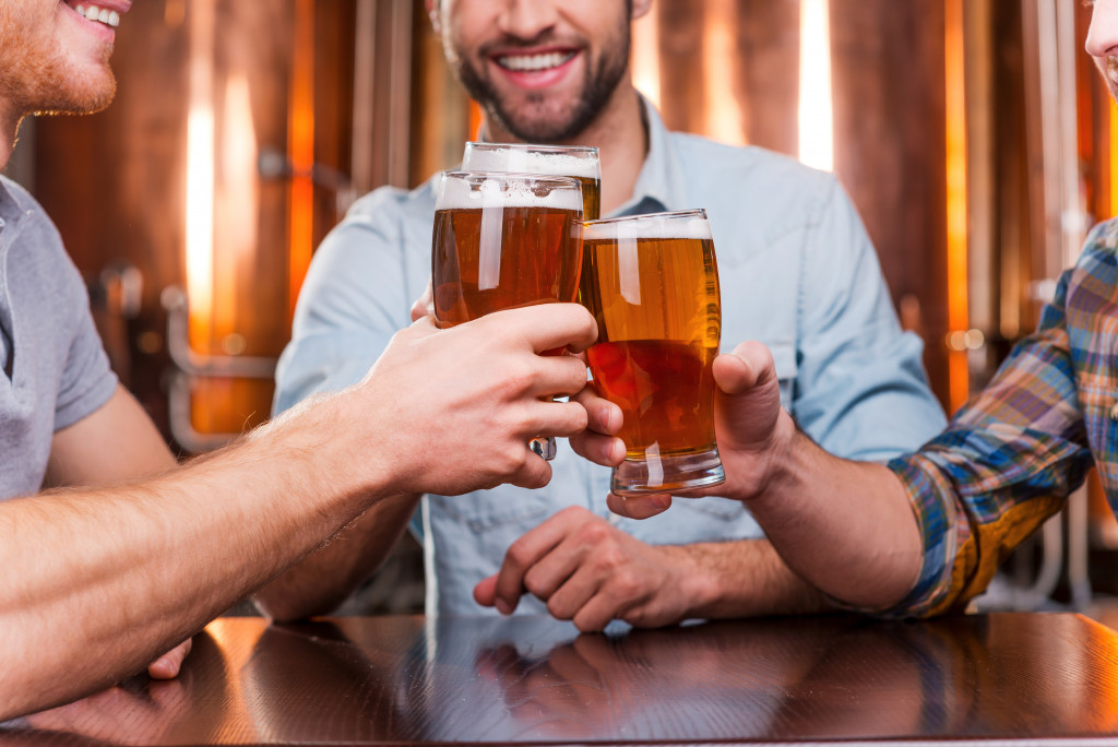 A group of male friends holding each a mug of beer