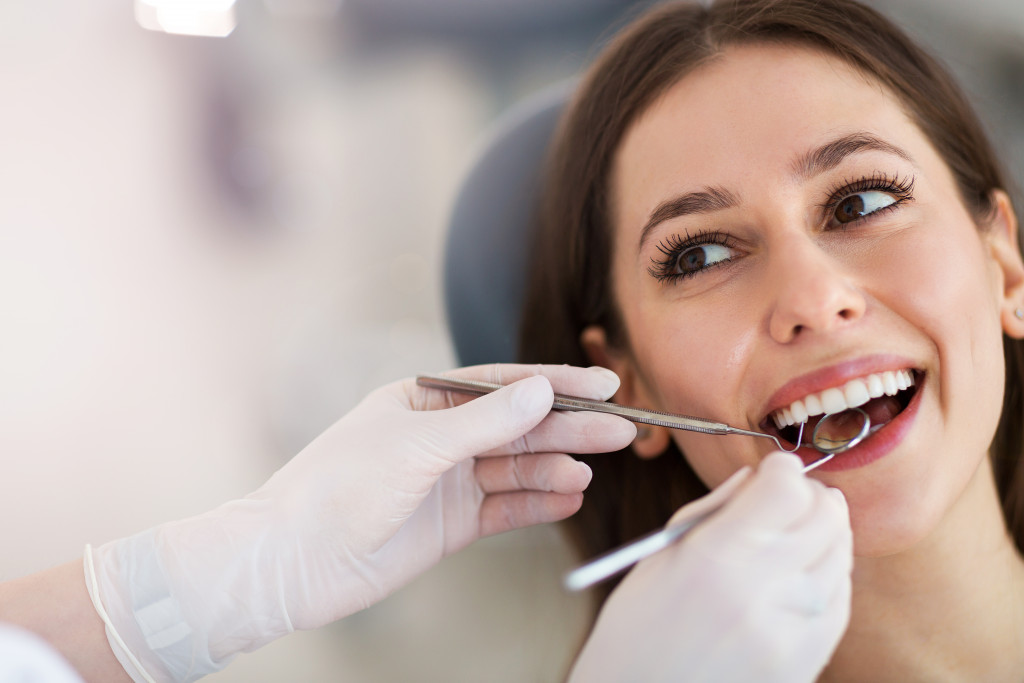 woman smiling while having her teeth checked at the dentist