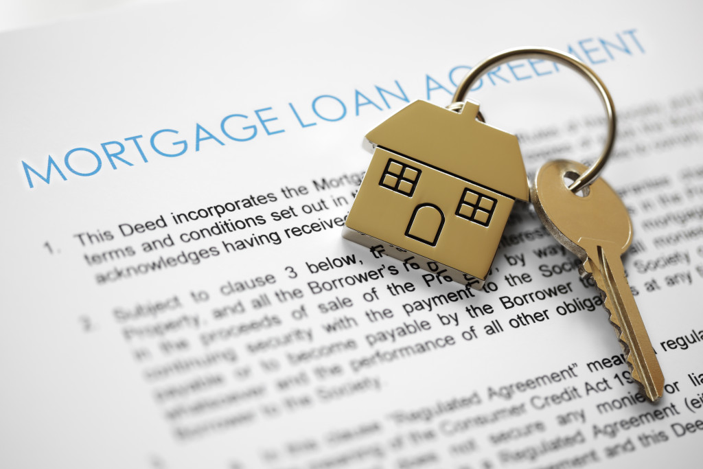 house key on top of mortgage loan agreement document