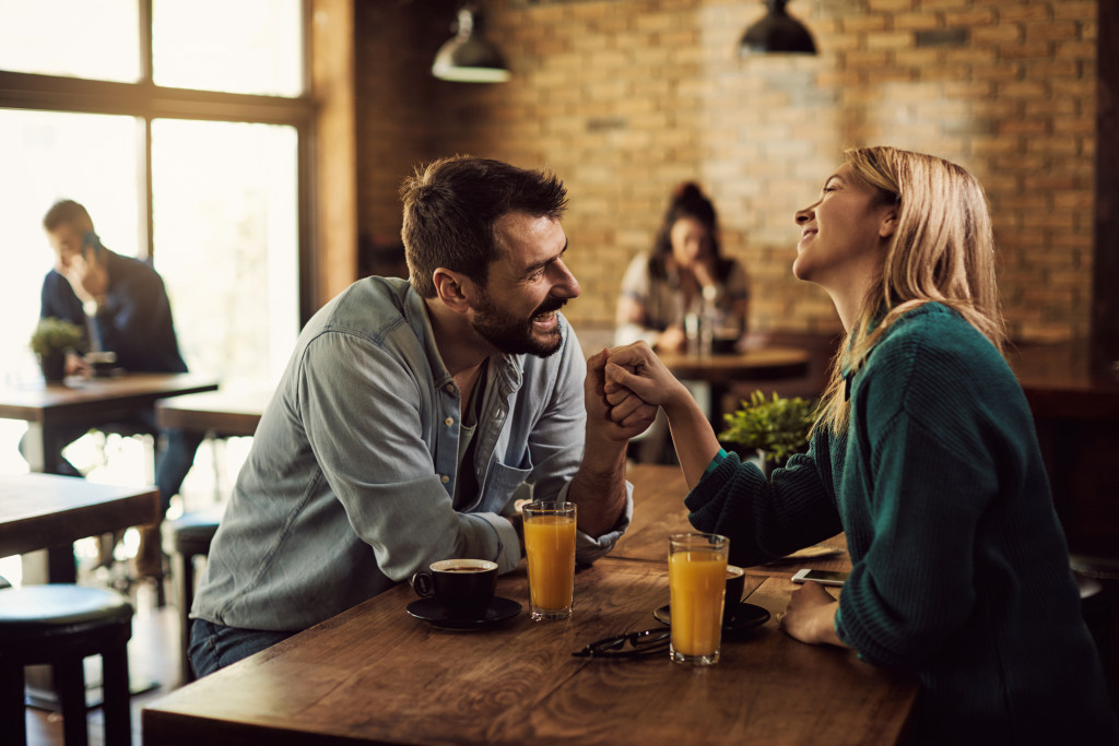 A man and woman talking at a cafe