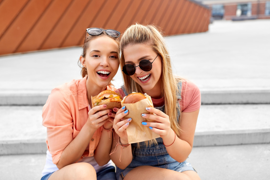 Teenage girls eating burgers