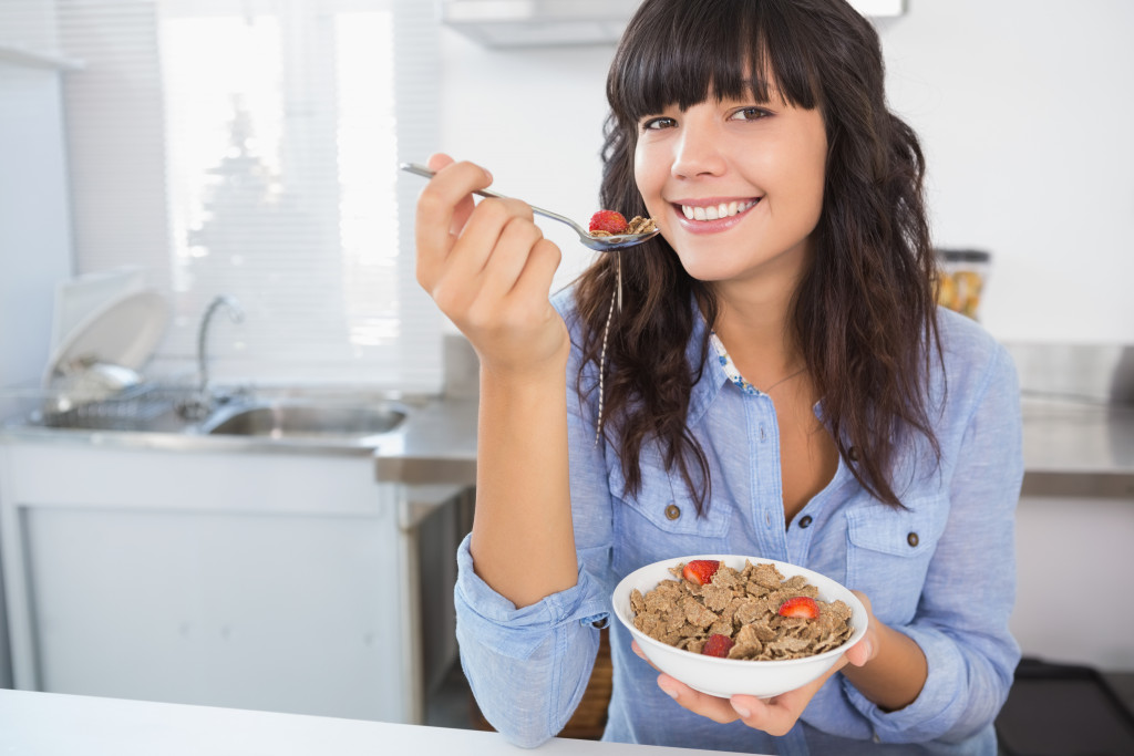 a yougn woman eating a bowl of cereal