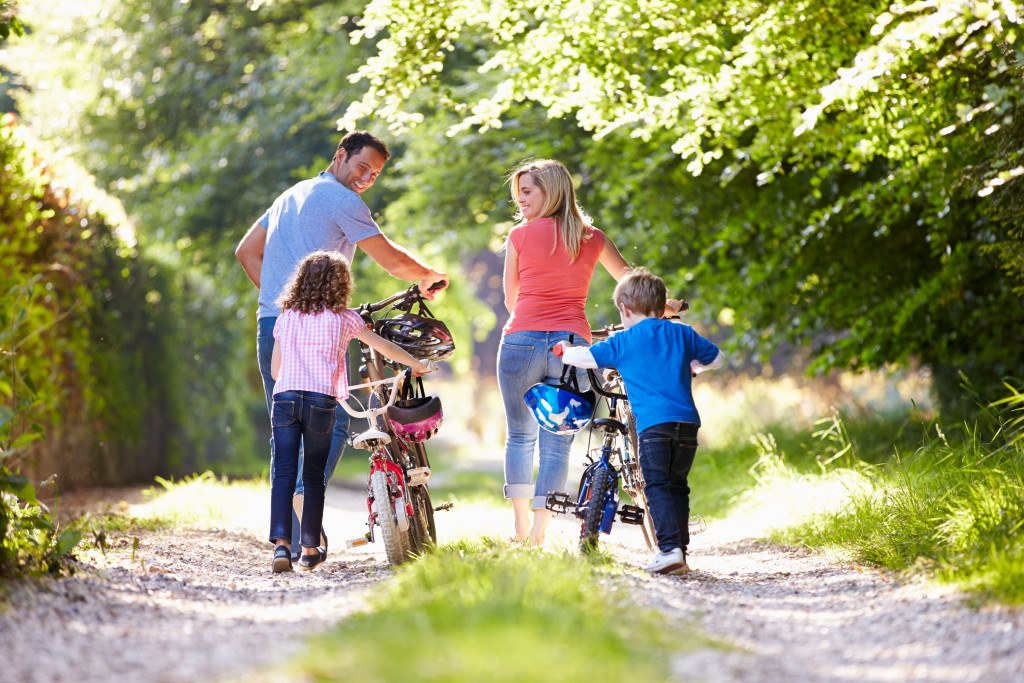 family with their own bikes walking in the park