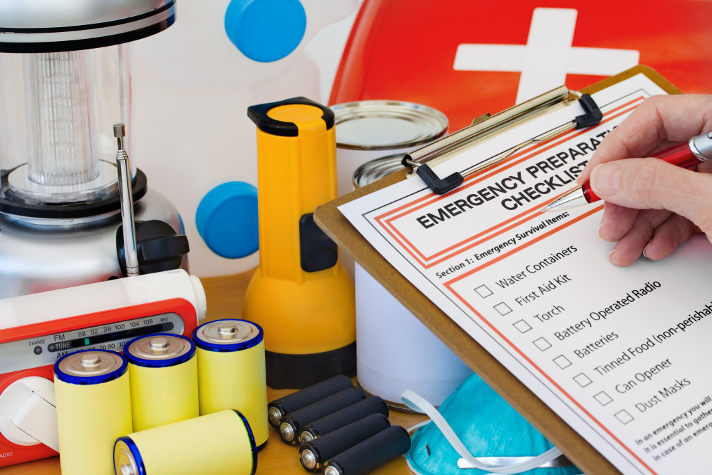 a person holding a clipboard checking the items listed on his first aid checklist