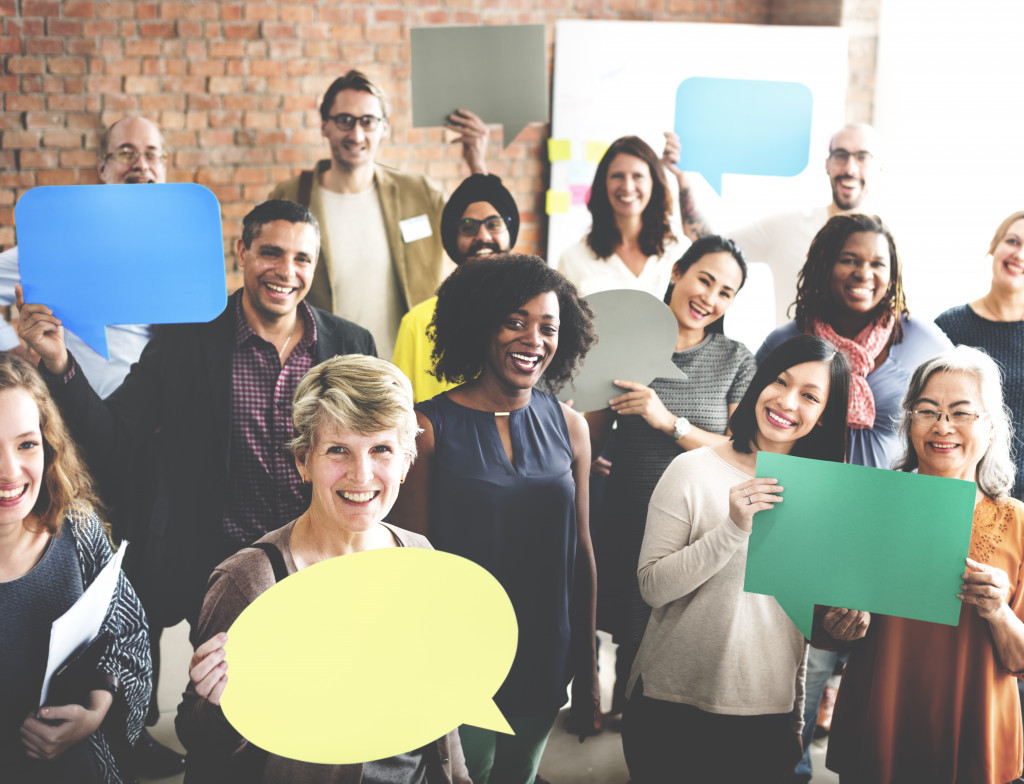 Employees holding chat bubble cutouts