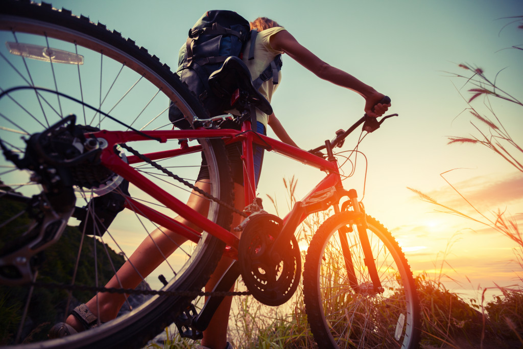 female hiker with bicycle during sunset