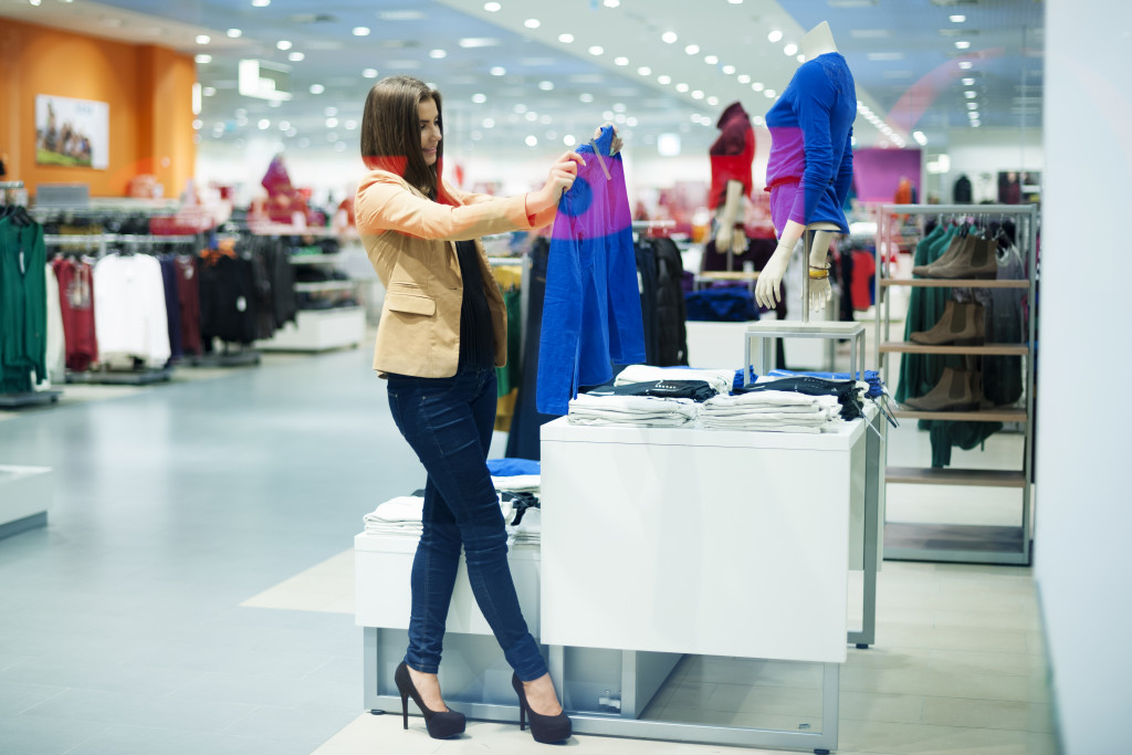 Young woman checking clothes at a store.