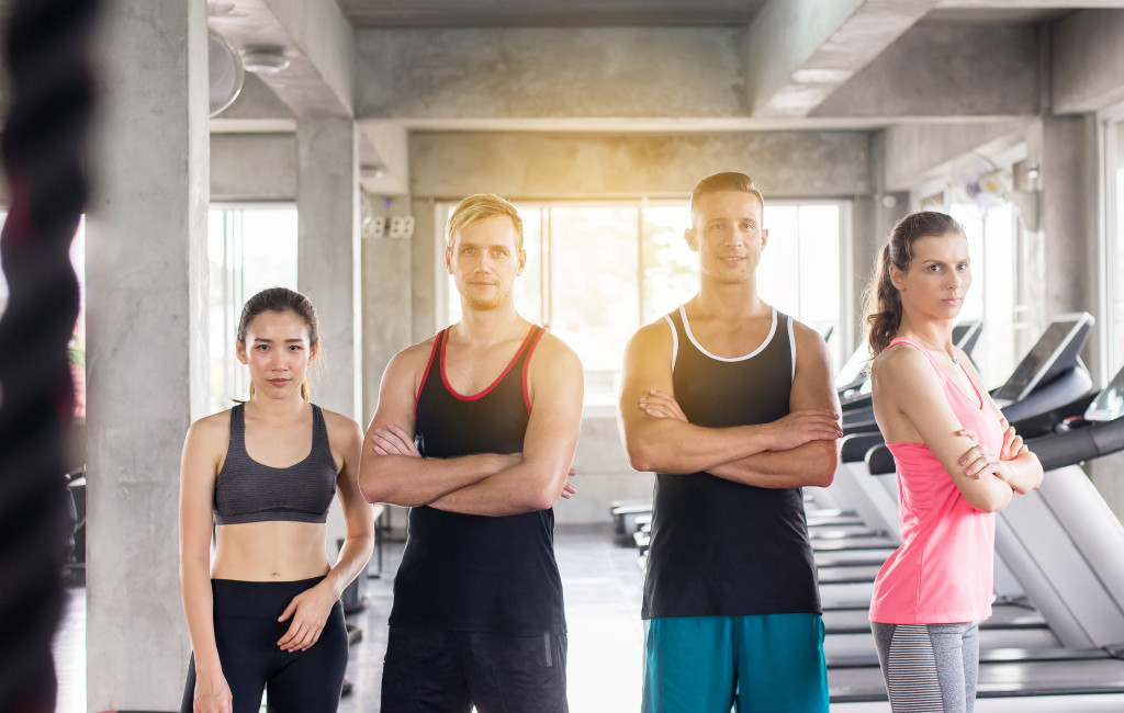 Group of four people standing inside a gym.