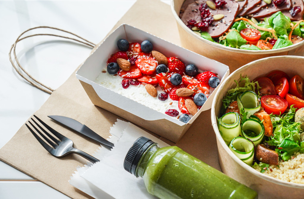 Fruits and vegetables prepared for meals with a knife and fork beside them.