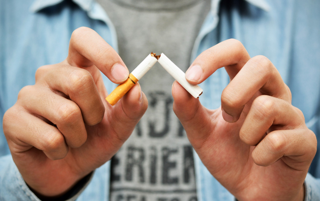 man cutting cigarette in half