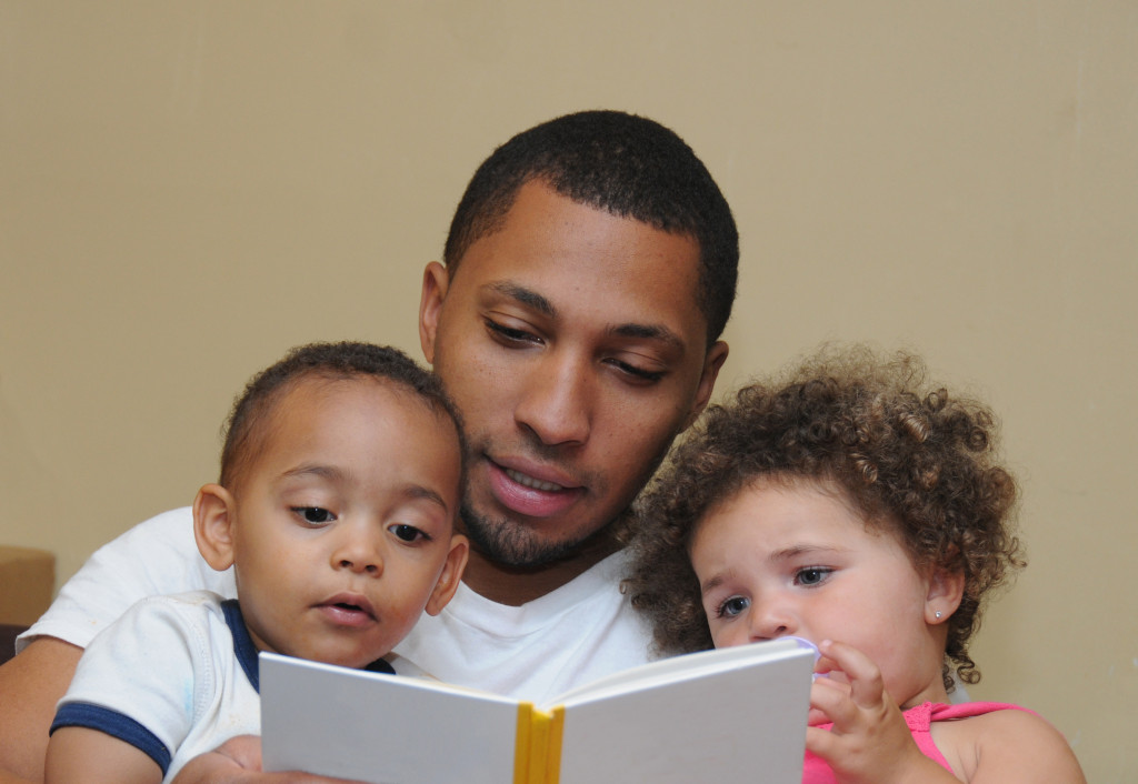 Father reading a book with his children.