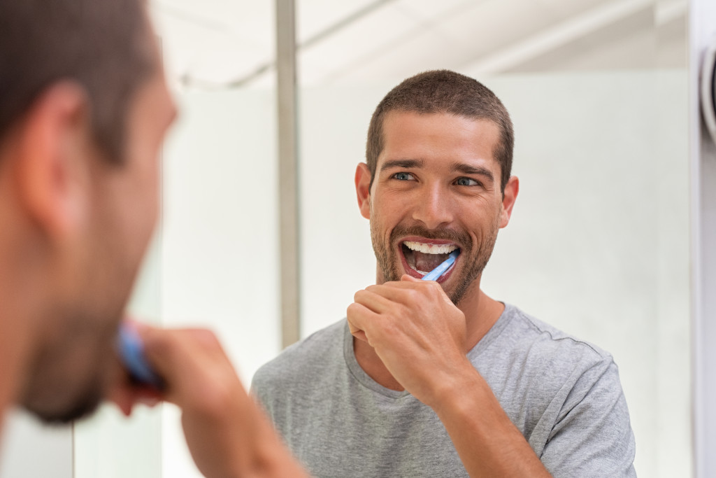 A man brushing his teeth happily