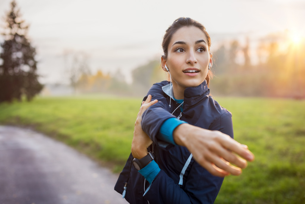 A woman stretching at a park before running