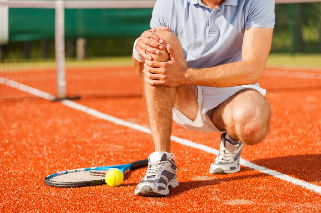 tennis player touching his leg