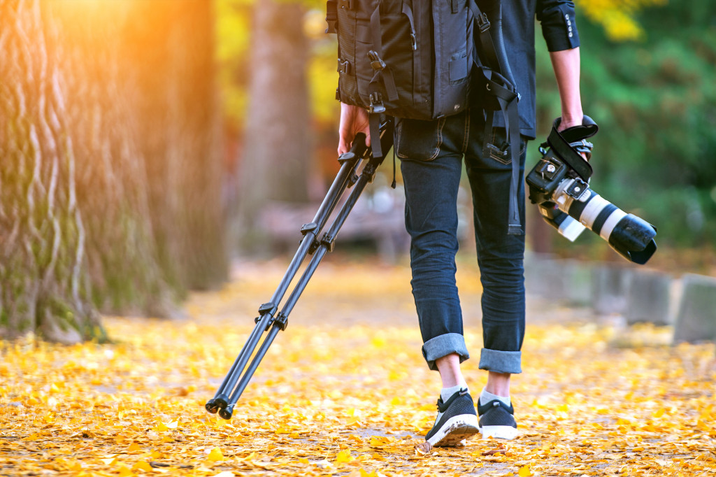 male photographer walking outdoor with gear