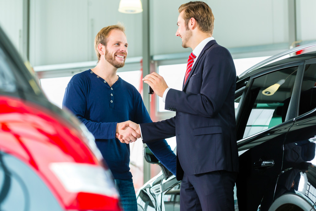 man with salesman getting a new car