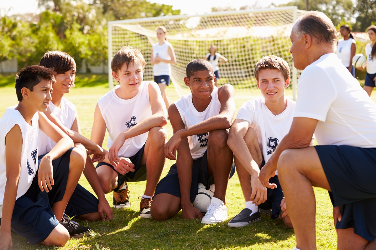 young players of football with their coach